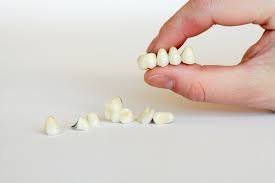 Ceramic crowns held between fingertips